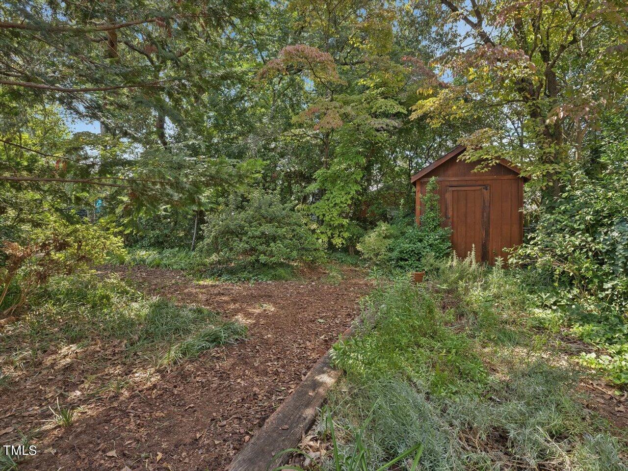 2129 Ridge Road Raleigh, NC 27607 - Photo 67 of 79 a view of a lush green yard with large trees and plants