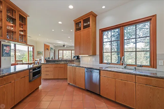a living room with couches a fireplace and a dining table with wooden floor