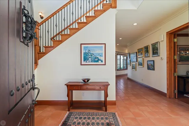 a kitchen with stainless steel appliances kitchen island granite countertop a dining table chairs and a refrigerator