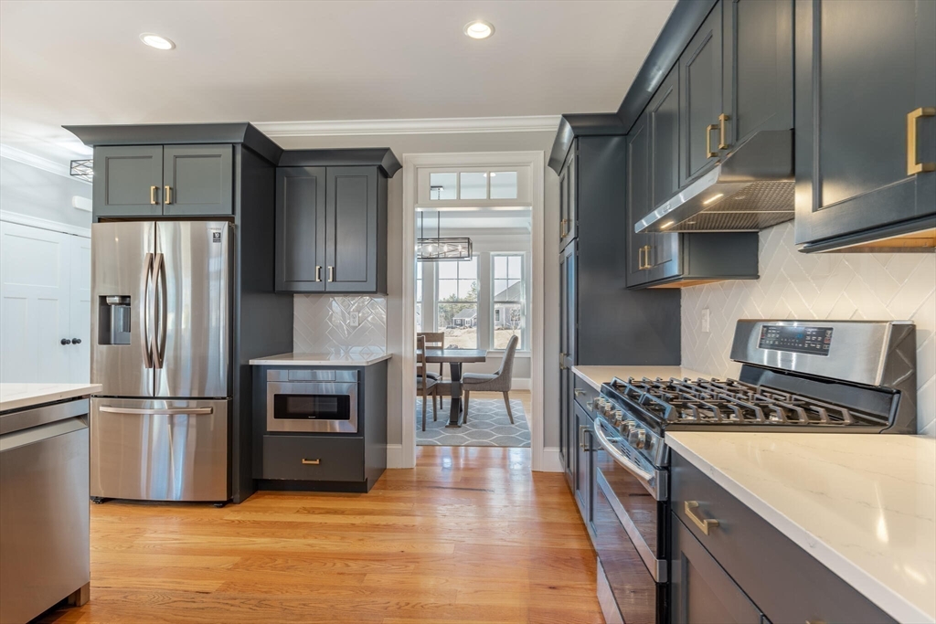 10 Rochambeau Avenue Wrentham, MA 02093 - Photo 15 of 40 a kitchen with stainless steel appliances granite countertop a refrigerator a stove and a sink with wooden floor