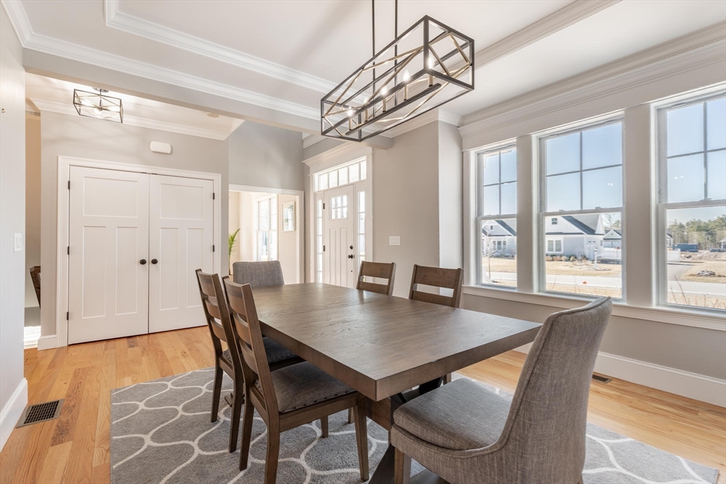 10 Rochambeau Avenue Wrentham, MA 02093 - Photo 8 of 40 a view of a dining room and livingroom with furniture wooden floor a chandelier