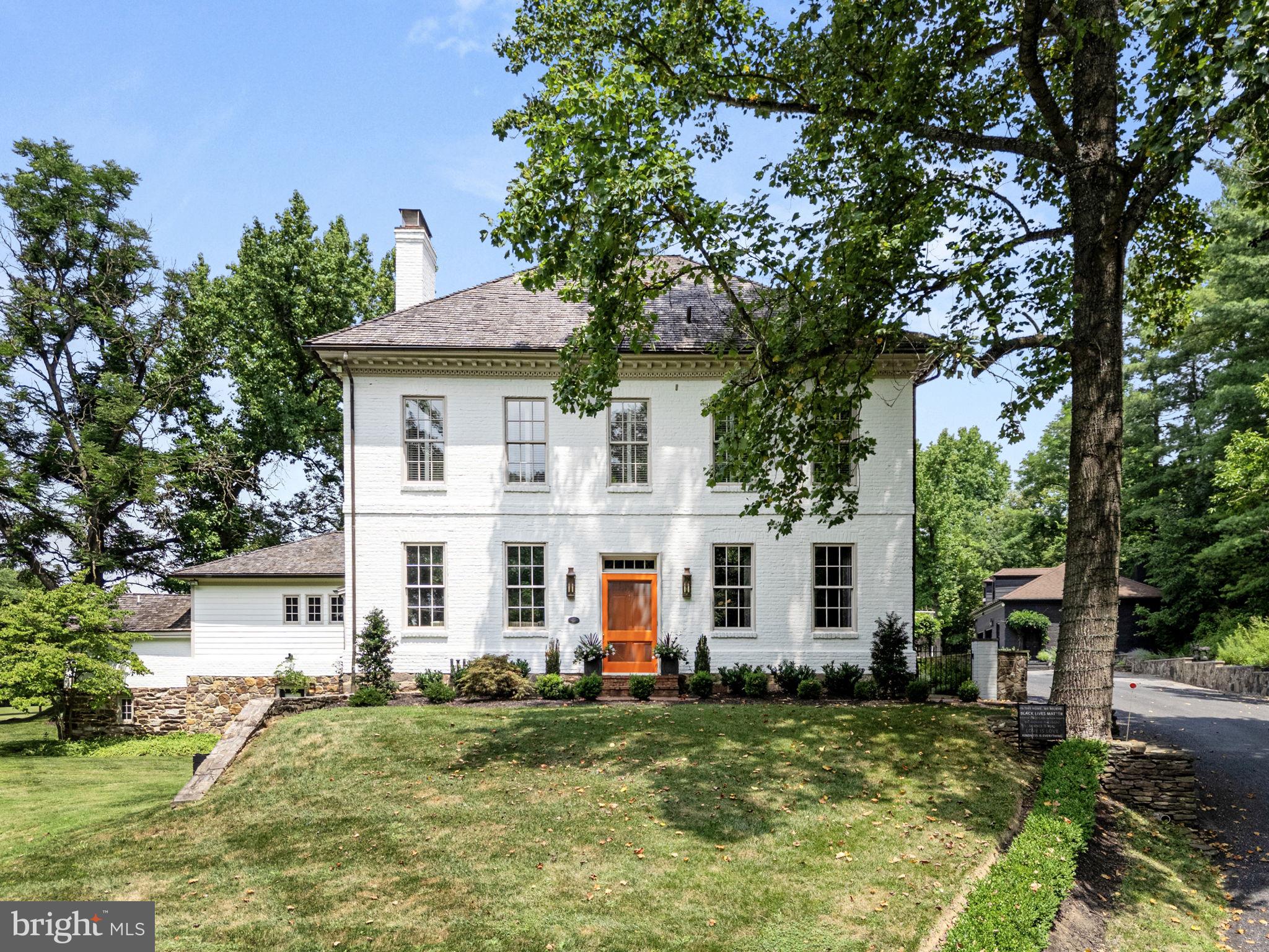 a view of a yard in front of a house with a large tree