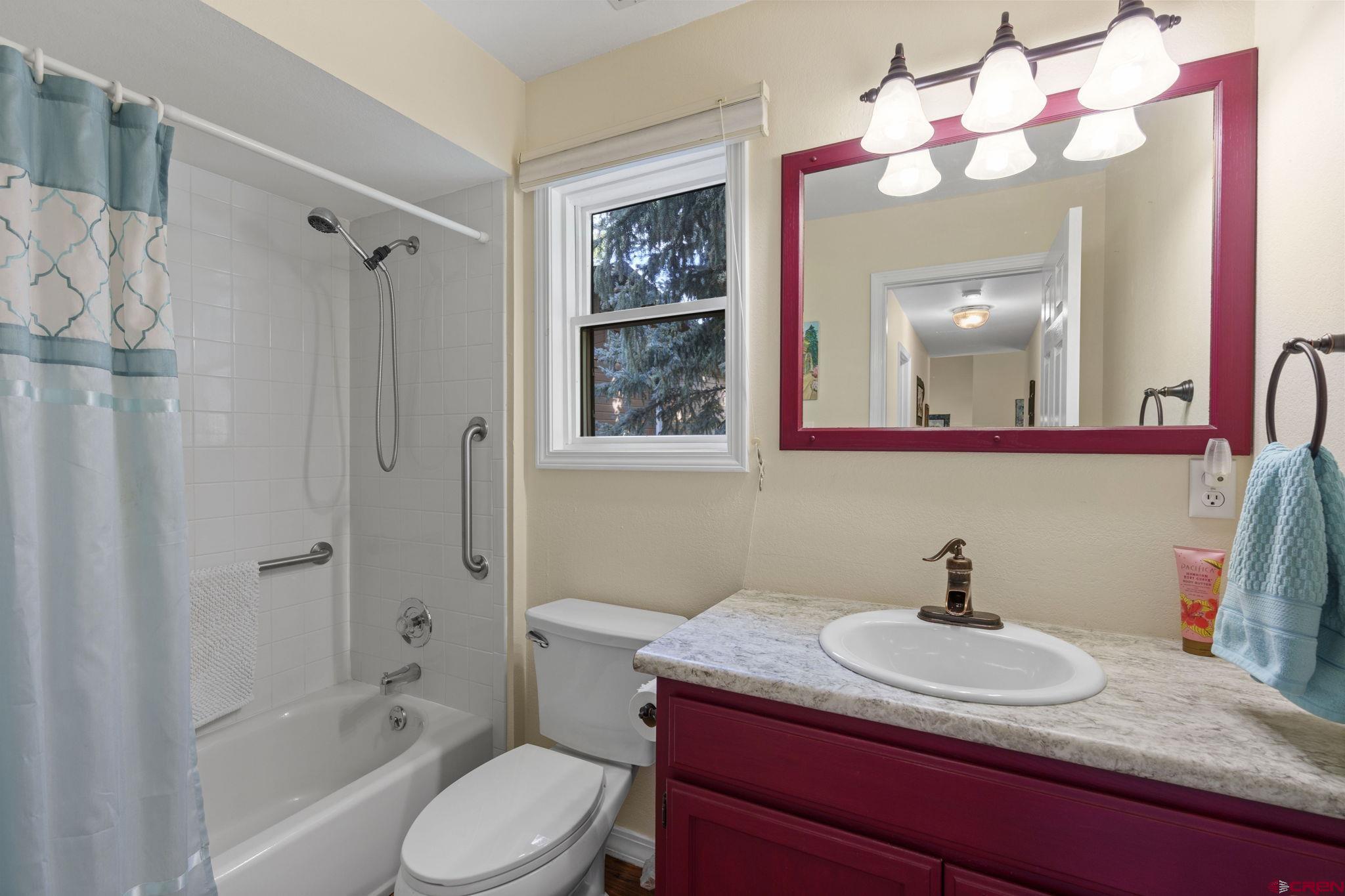 840 Waterfall Lane Durango, CO 81301 - Photo 22 of 31 a bathroom with a granite countertop sink vanity mirror bathtub and toilet