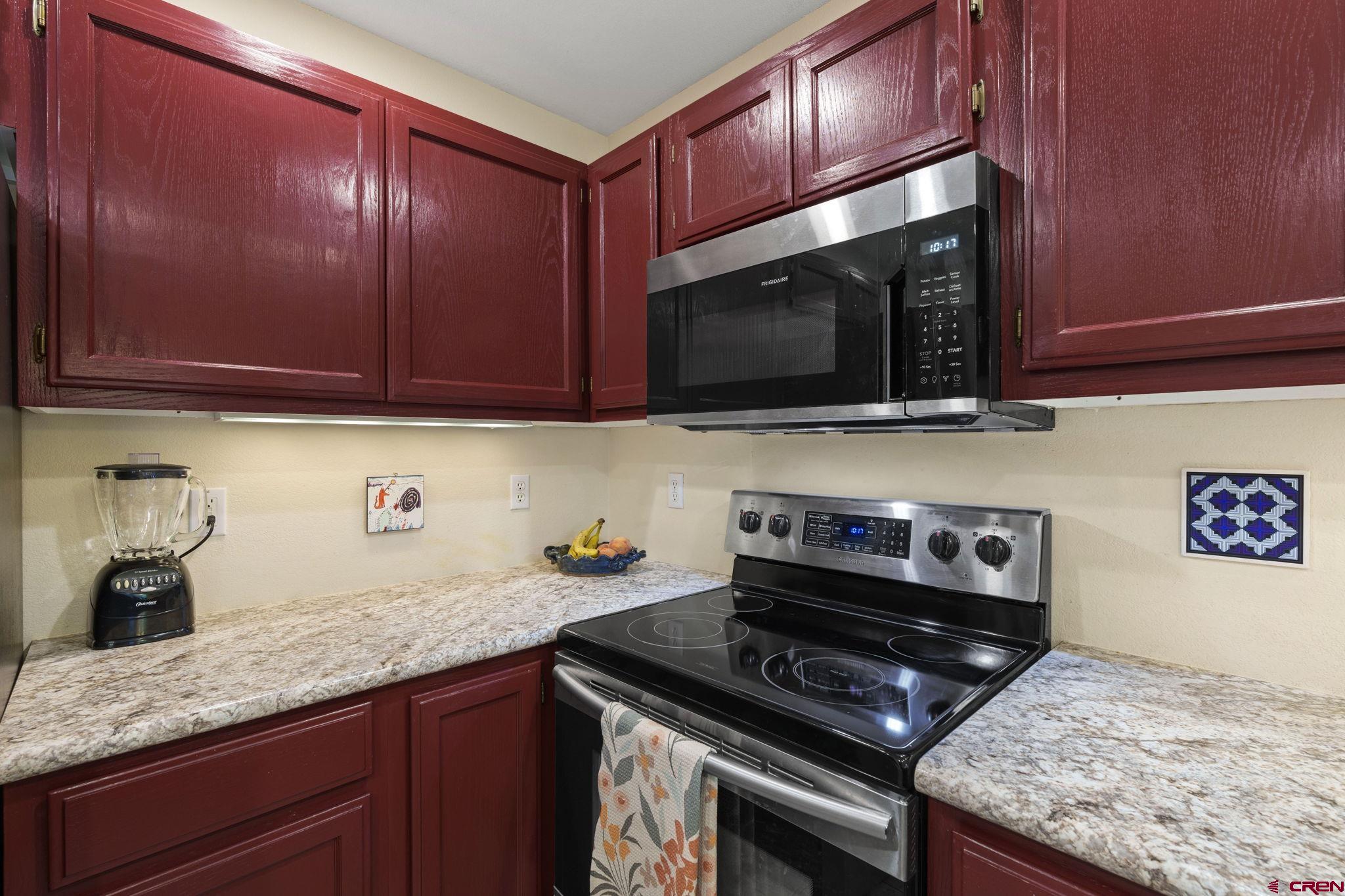 840 Waterfall Lane Durango, CO 81301 - Photo 10 of 31 a kitchen with granite countertop stainless steel appliances a stove microwave and sink