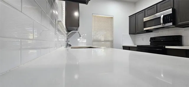 a view of a kitchen with stainless steel appliances cabinets and a window