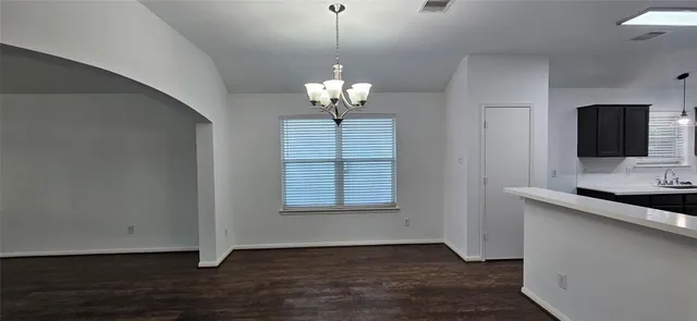 a view of wooden floor and a chandelier in a room