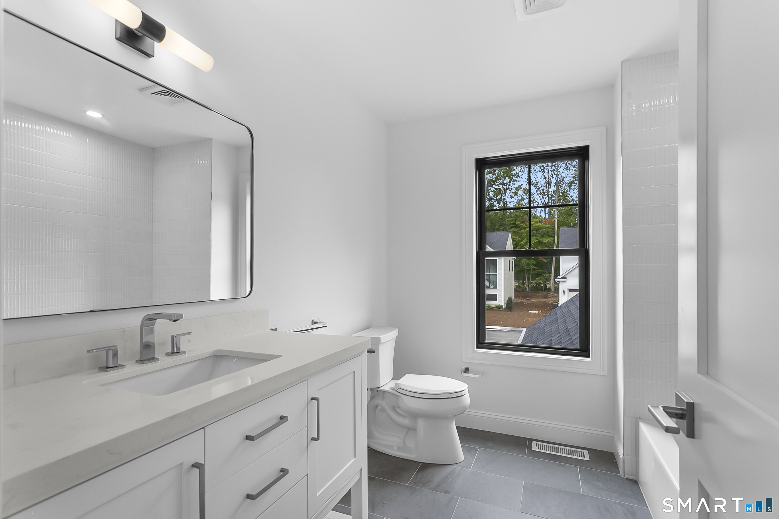 95 Oronoque Lane Stratford, CT 06614 - Photo 24 of 30 a bathroom with a granite countertop sink a toilet and a window