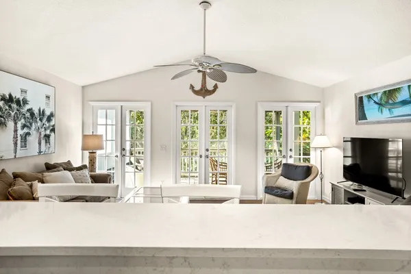 a living room with furniture a flat screen tv and a large window