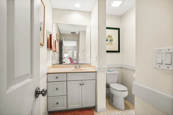a bathroom with a granite countertop toilet sink and mirror