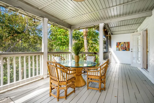 a view of a porch with furniture and wooden floor