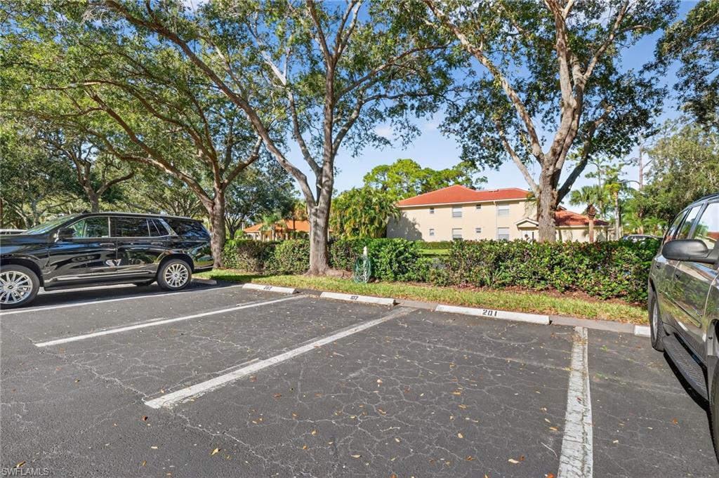 209 Robin Hood Circle, Unit 201 Naples, FL 34104 - Photo 16 of 29 a car parked on the side of a street