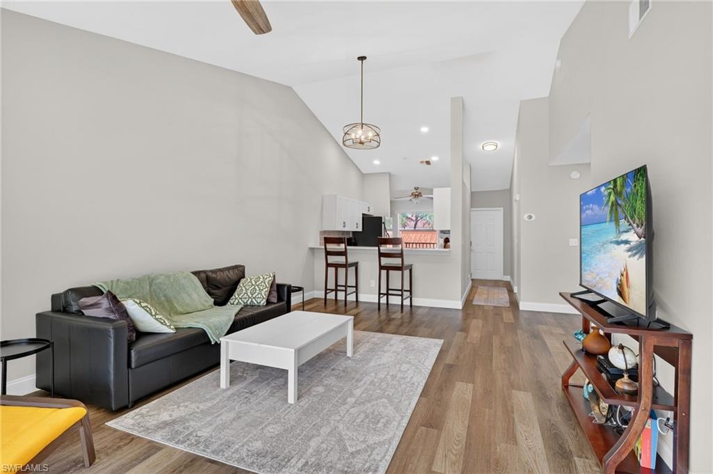 209 Robin Hood Circle, Unit 201 Naples, FL 34104 - Photo 5 of 29 a living room with furniture and wooden floor