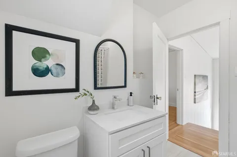 a bathroom with a sink a toilet and a mirror