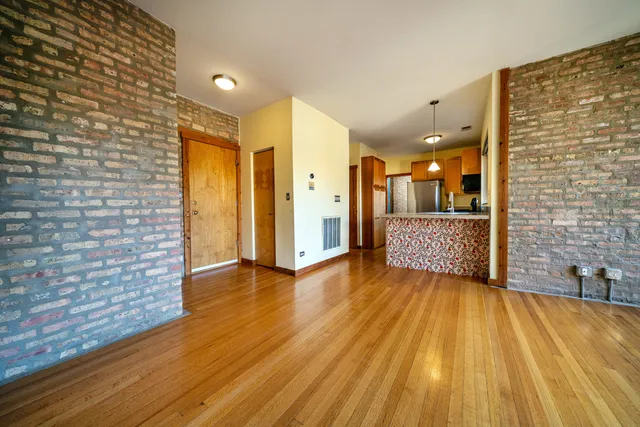 a view of a hallway with wooden floor and a bathroom