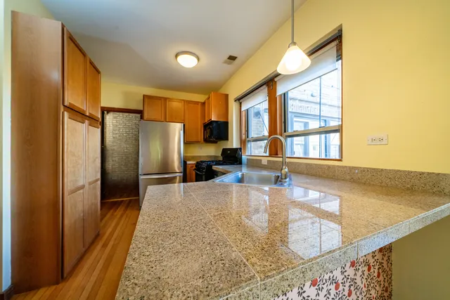 a kitchen with stainless steel appliances granite countertop a refrigerator and a sink