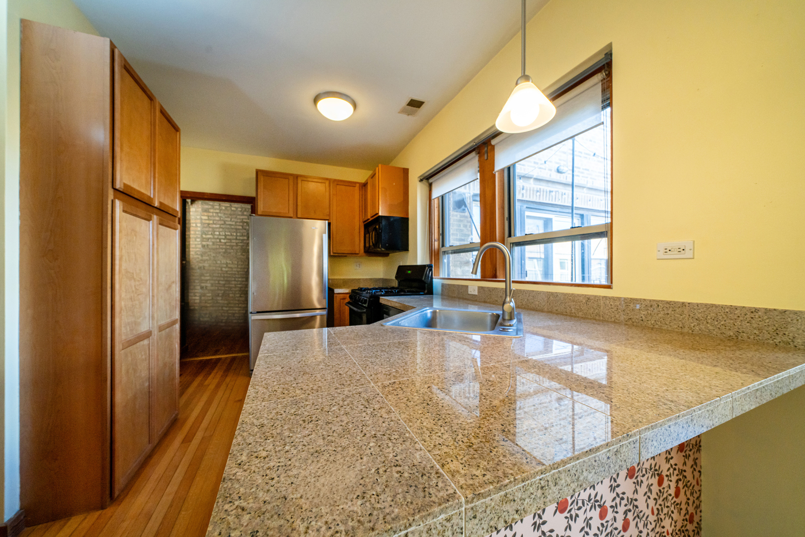 1225 West Greenleaf Avenue, Unit 3W Chicago, IL 60626 - Photo 4 of 13 a kitchen with stainless steel appliances granite countertop a refrigerator and a sink