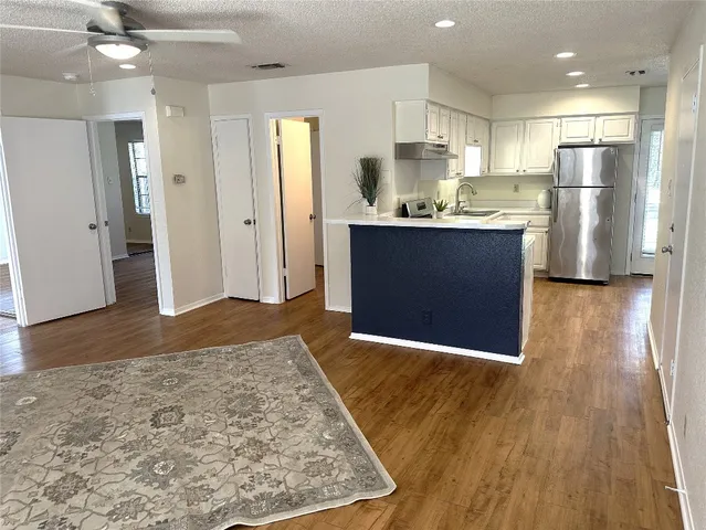 a view of kitchen with refrigerator microwave and wooden floor