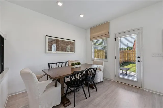 a kitchen with stainless steel appliances a stove a sink a refrigerator and white cabinets with wooden floor