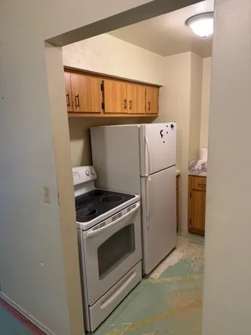 a kitchen with a stove top oven and refrigerator