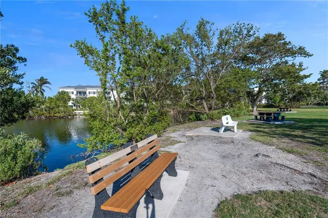 a view of a bench in the garden near a lake