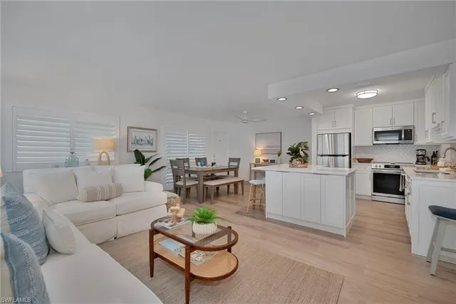 a living room with furniture kitchen and a table