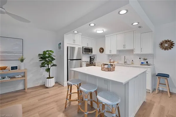 a kitchen with white cabinets and white appliances