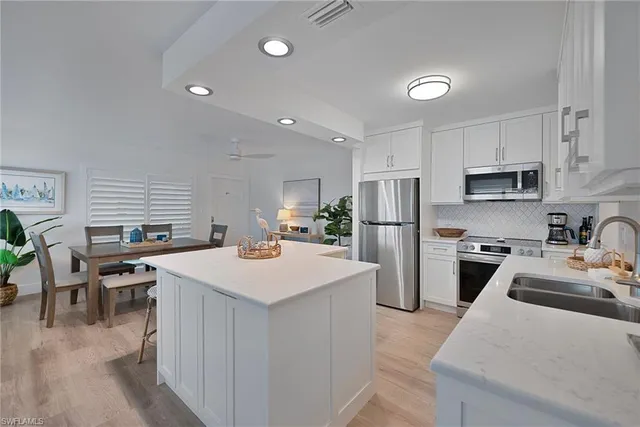 a kitchen that has a lot of cabinets a sink and a stove in it