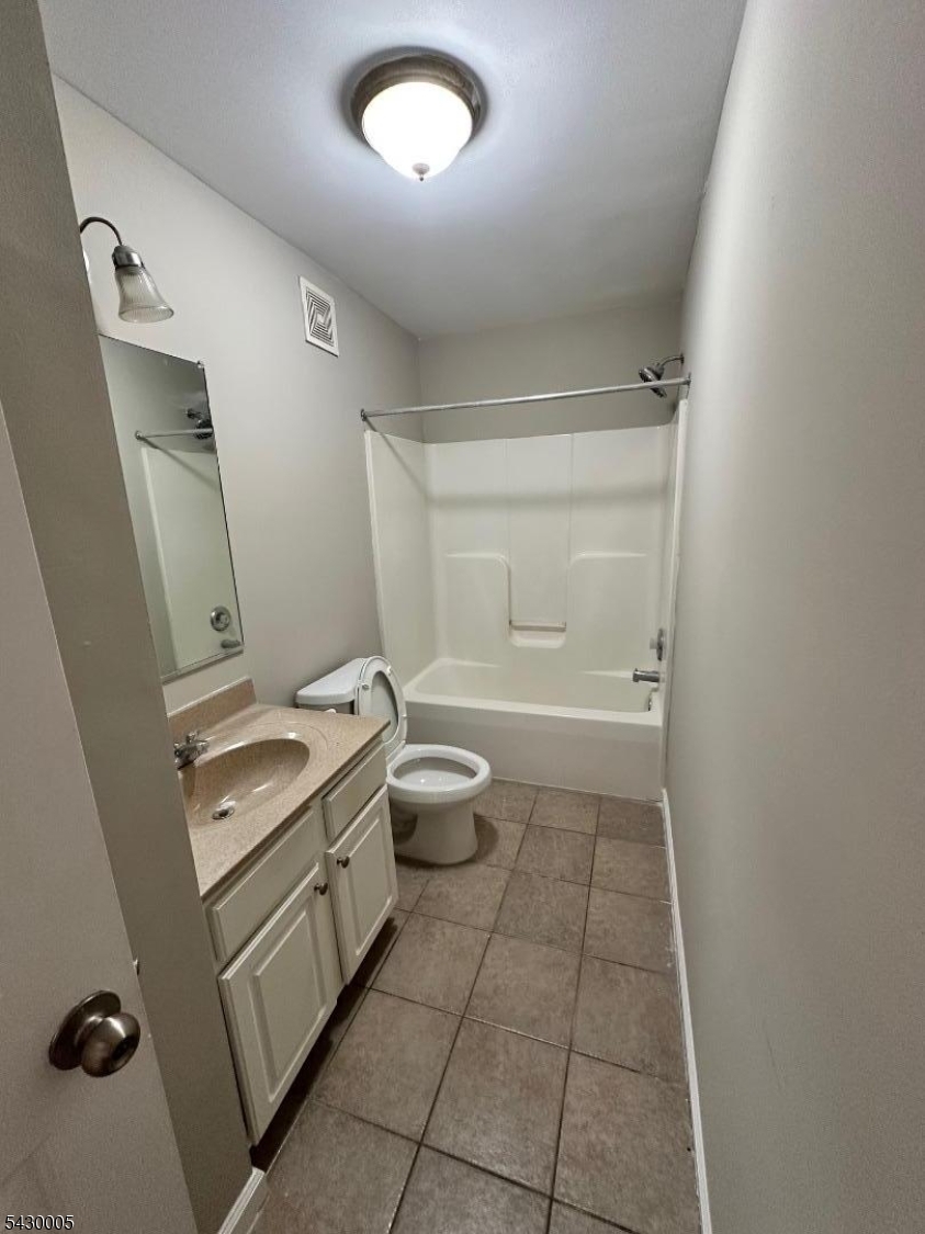 63 Garret Street, Unit 2 Paterson, NJ 07501 - Photo 4 of 9 a bathroom with a granite countertop sink a toilet and a mirror