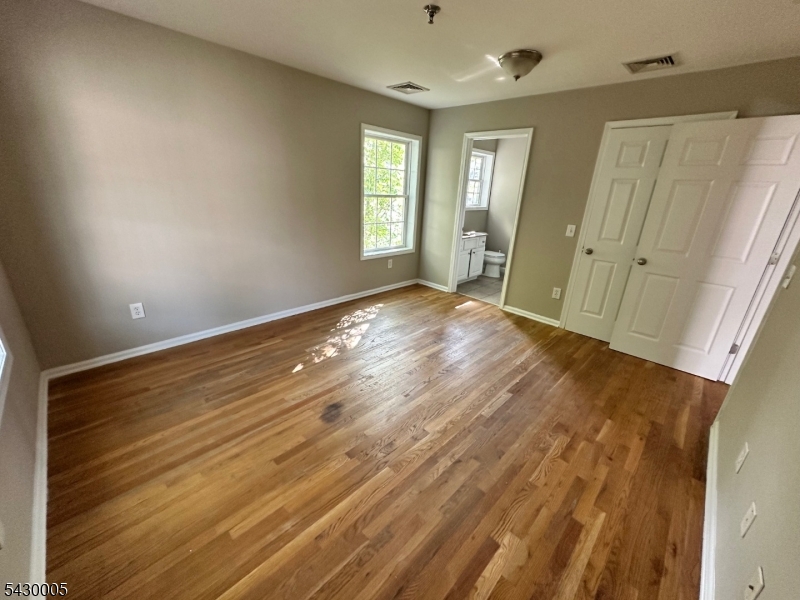 63 Garret Street, Unit 2 Paterson, NJ 07501 - Photo 6 of 9 an empty room with wooden floor and windows
