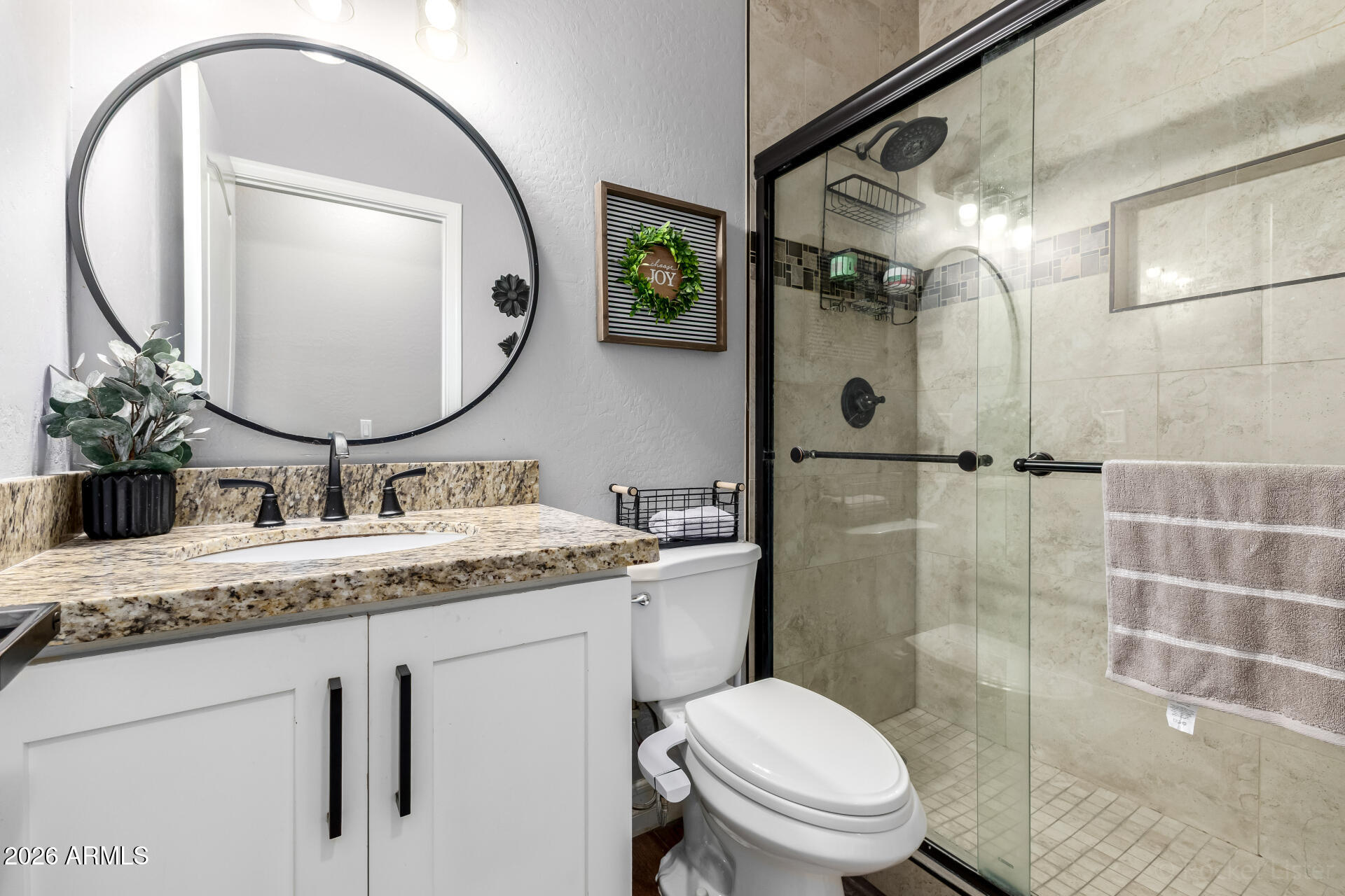 9646 West Payson Road Tolleson, AZ 85353 - Photo 28 of 36 a bathroom with a granite countertop sink mirror toilet and shower