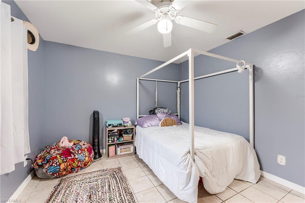 18257 Huckleberry Road Fort Myers, FL 33967 - Photo 12 of 18 a bedroom with a bed and a chandelier