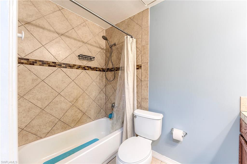 18257 Huckleberry Road Fort Myers, FL 33967 - Photo 13 of 18 a white toilet sitting next to a bath tub and a shower