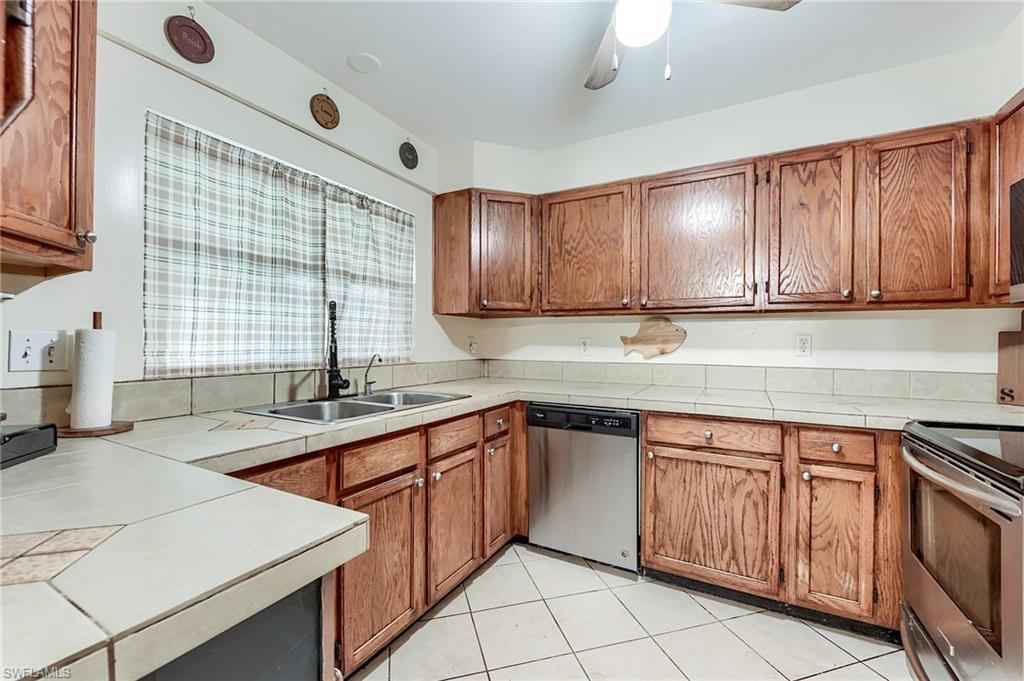 18257 Huckleberry Road Fort Myers, FL 33967 - Photo 7 of 18 a kitchen with a sink stove and cabinets