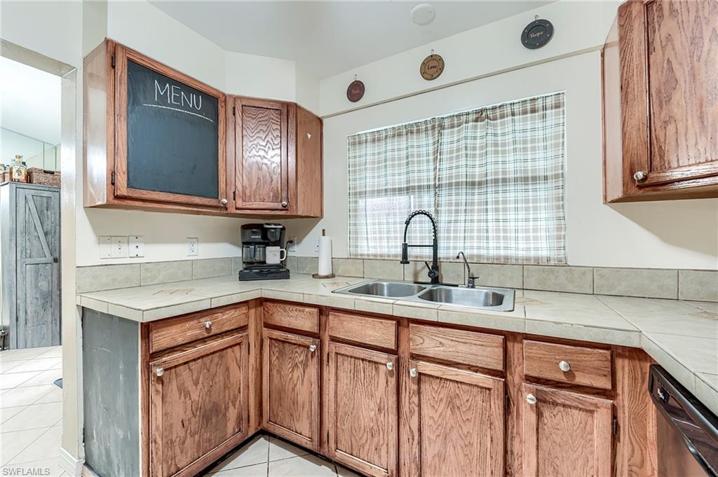 18257 Huckleberry Road Fort Myers, FL 33967 - Photo 8 of 18 a kitchen with stainless steel appliances granite countertop a sink and cabinets with wooden floor