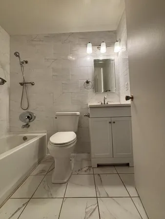 a bathroom with a toilet sink and mirror