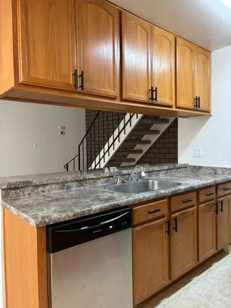 a kitchen with granite countertop a sink and cabinets
