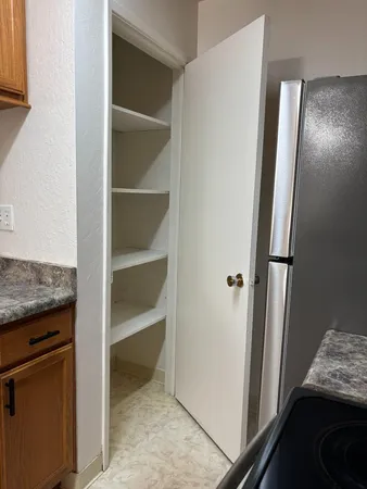a view of kitchen with refrigerator and wooden floor
