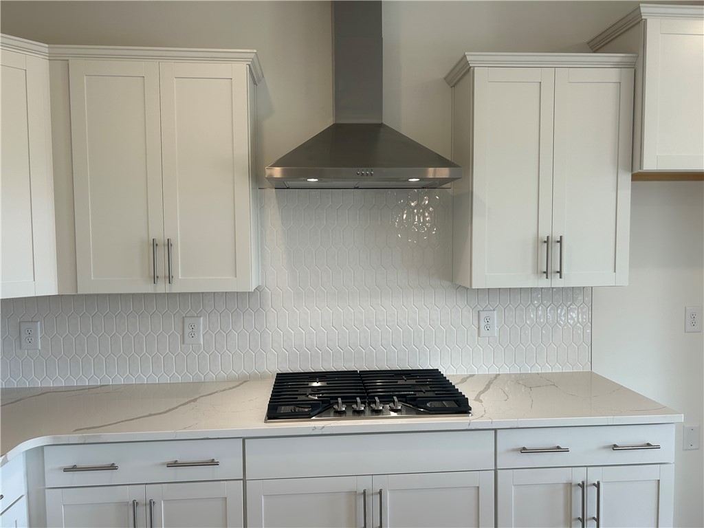 217 Bellflower Lane Anderson, SC 29625 - Photo 10 of 27 A well-lit kitchen featuring elegant white cabinetry, a gas cooktop, and a stylish range hood.