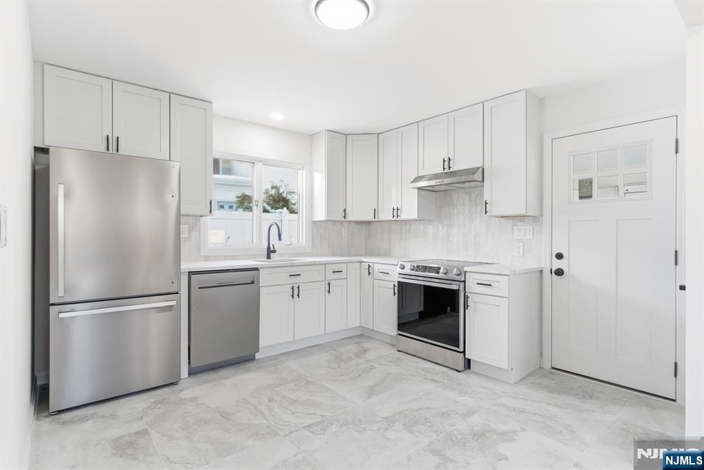 751 Hanson Avenue Perth Amboy, NJ 08861 - Photo 15 of 25 a kitchen with stainless steel appliances white cabinets and a refrigerator