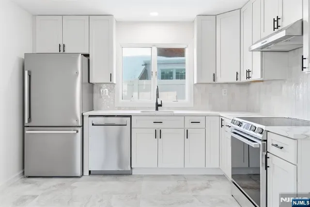 a kitchen with white cabinets and white appliances