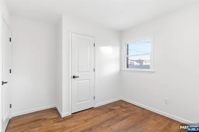 a view of a small space with wooden floor and a window