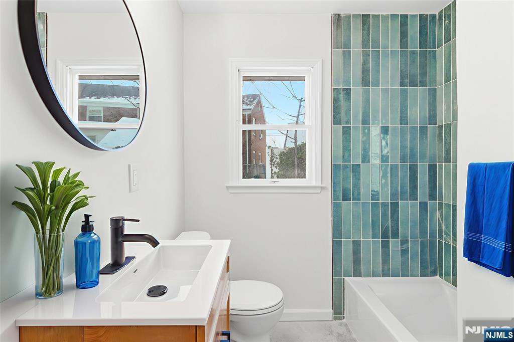 751 Hanson Avenue Perth Amboy, NJ 08861 - Photo 10 of 25 a bathroom with a sink a toilet a mirror and shower