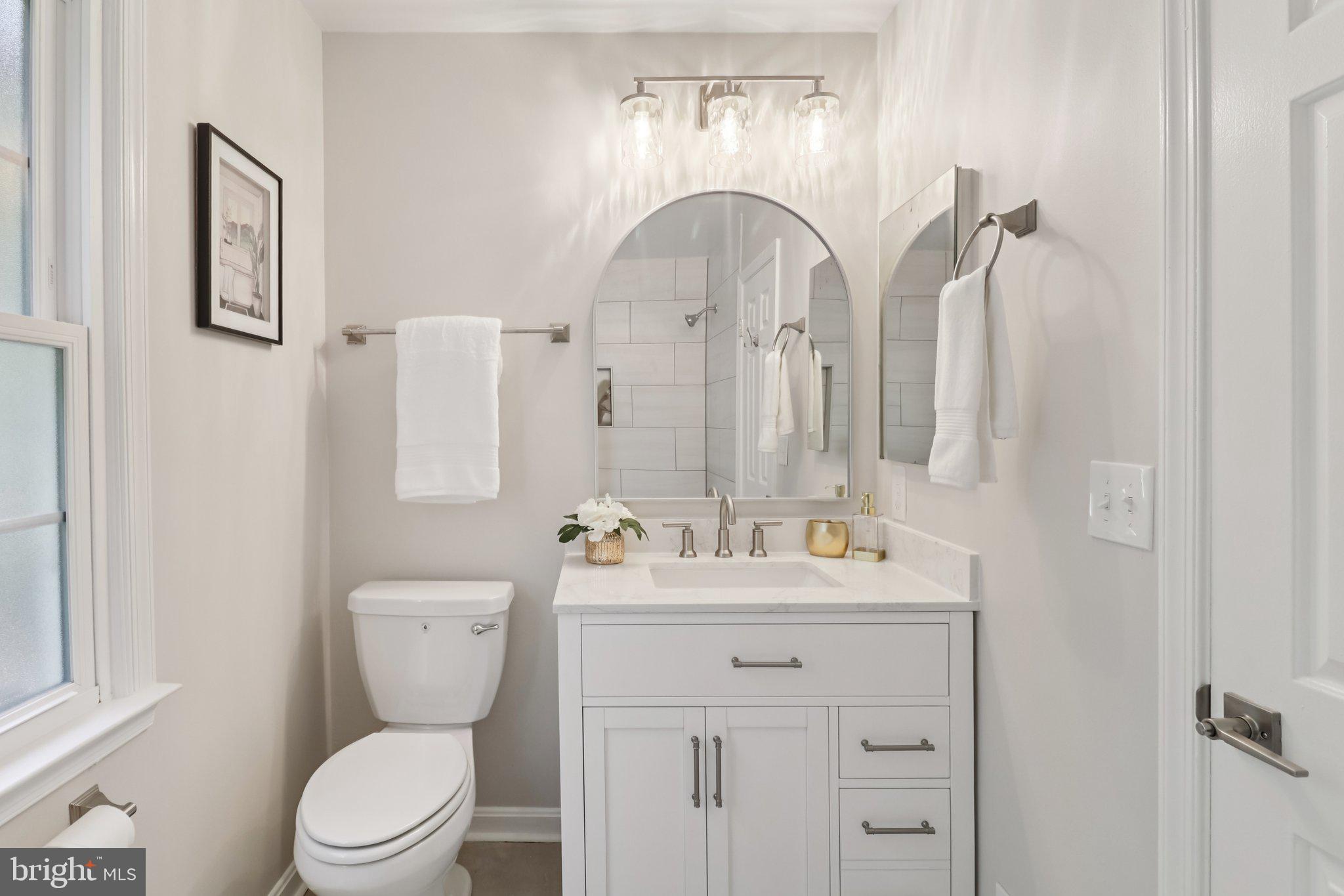 13229 Osterport Drive Silver Spring, MD 20906 - Photo 25 of 40 a bathroom with a sink a toilet and a mirror