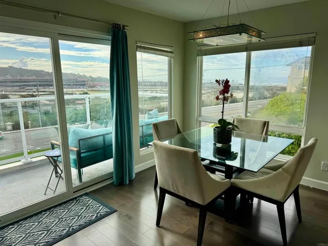 a living room with furniture a wooden floor and kitchen view