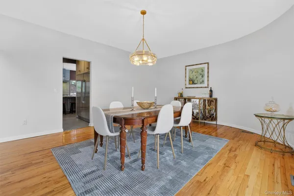 a dining room with furniture a chandelier and wooden floor