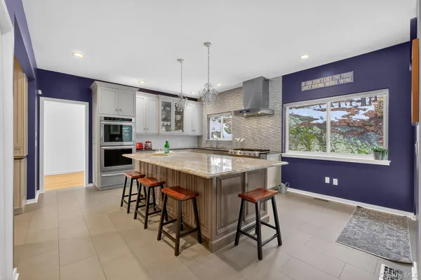 a kitchen with stainless steel appliances granite countertop a sink a stove a refrigerator and wooden cabinets