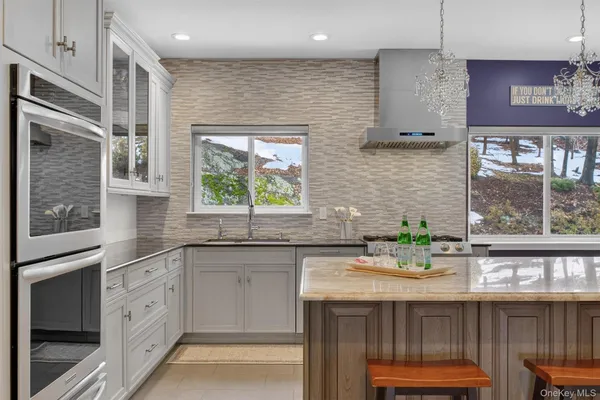 a kitchen with stainless steel appliances granite countertop a sink stove and cabinets