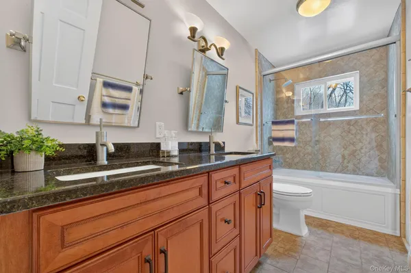a bathroom with a granite countertop sink a toilet and a bathtub