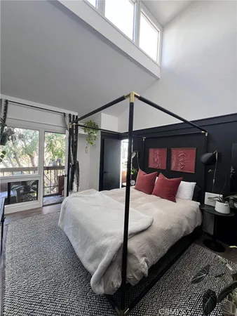 a bedroom with a bed large window with outer view and balcony view