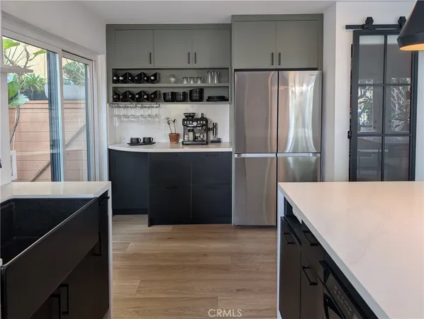 a kitchen with stainless steel appliances a refrigerator and a stove with wooden floor